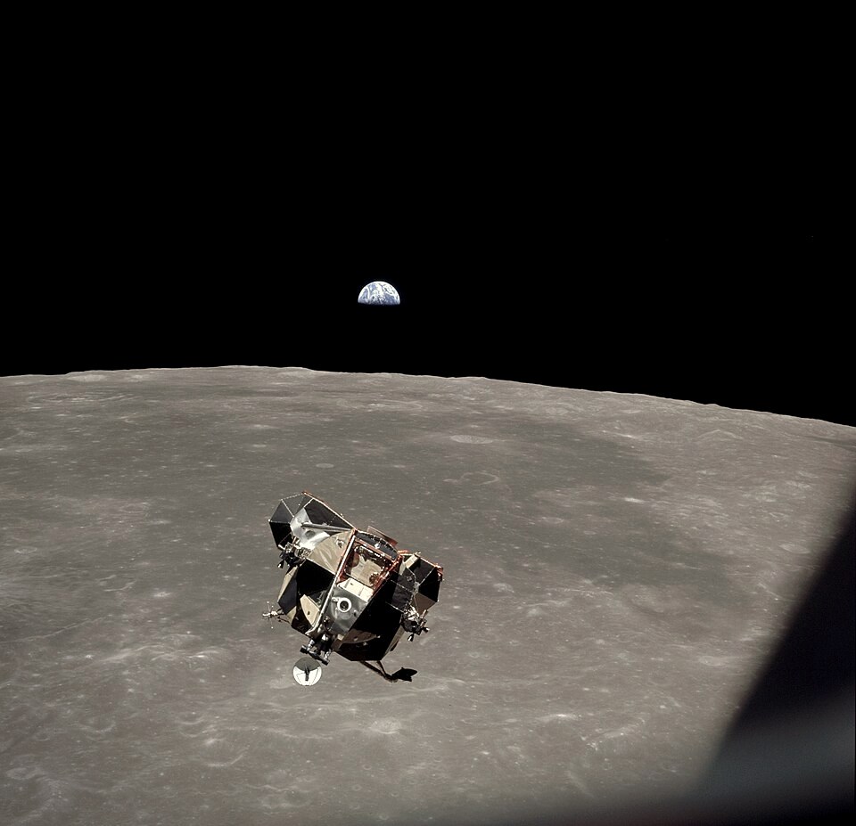 Lunar module Eagle in flight above the Moon's surface with Earth in the distance, taken by Michael Collins from the Apollo 11 command module on 21 July 1969.